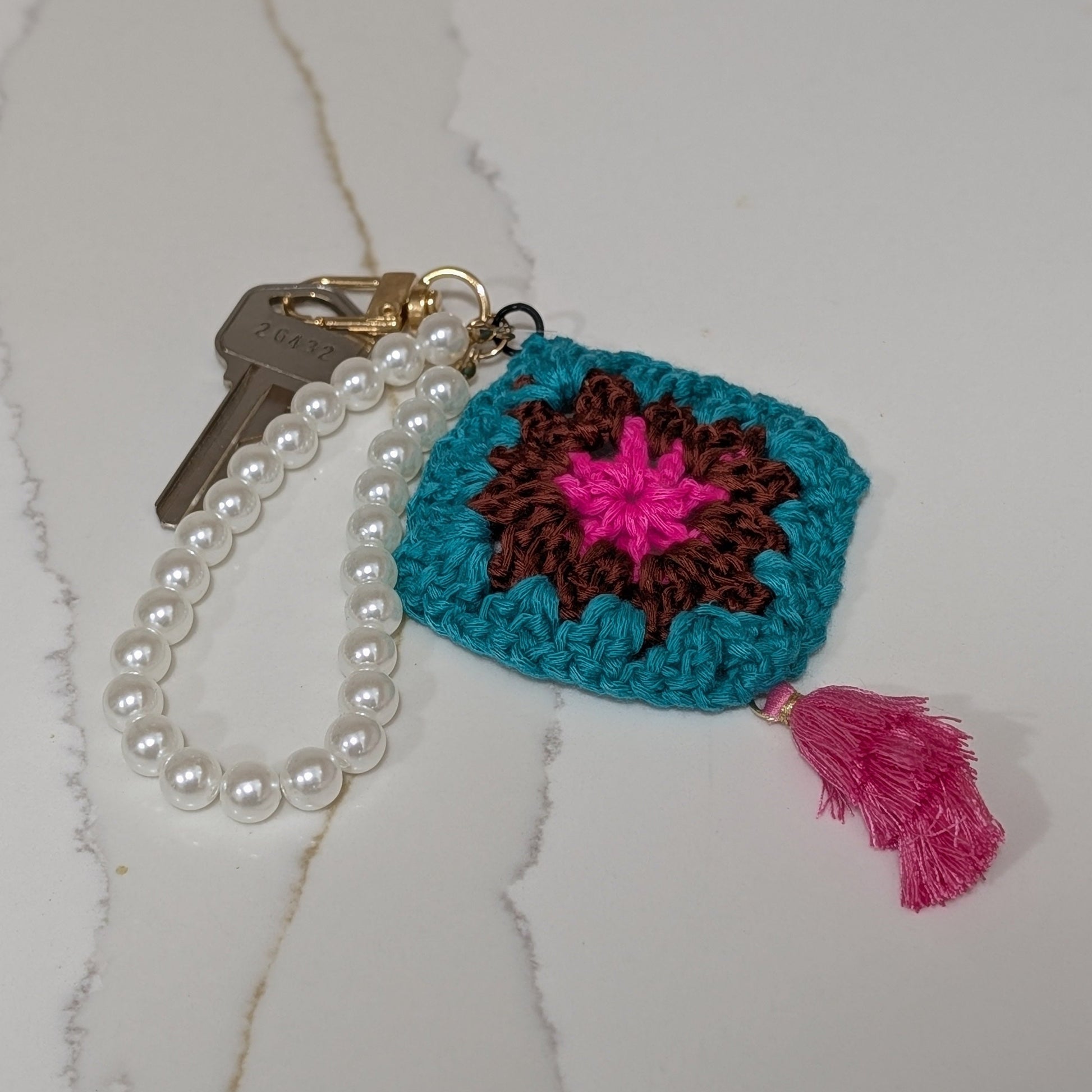 Crocheted keychain with colorful design on a white textured surface