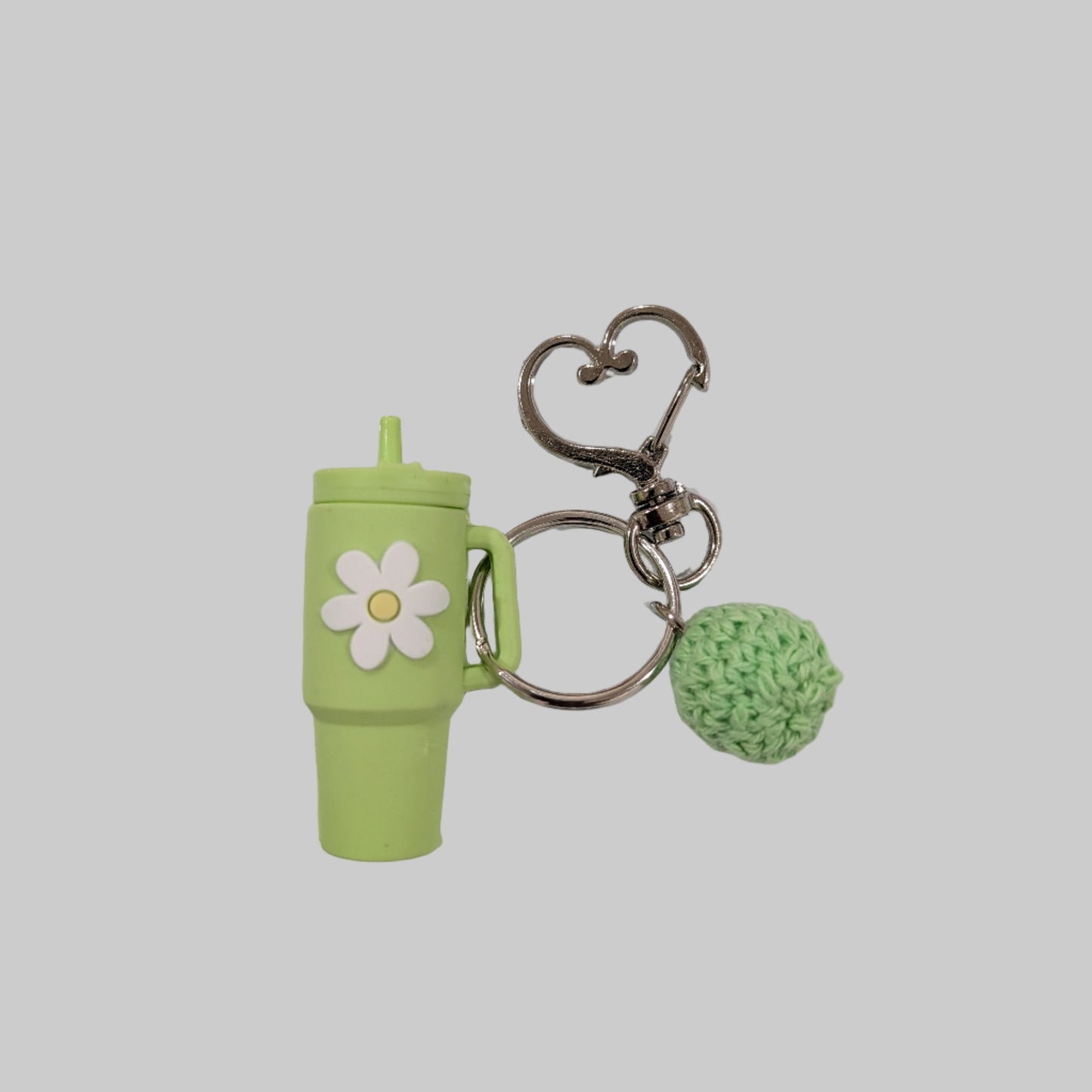Green little silicone tumbler keychain with a flower design on a white background
