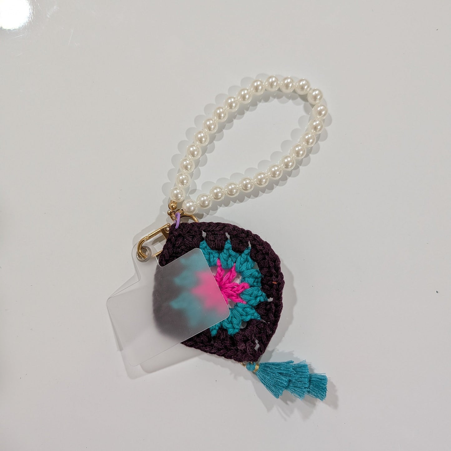 Small crocheted keychain and beads bracelet with colorful design on a white background