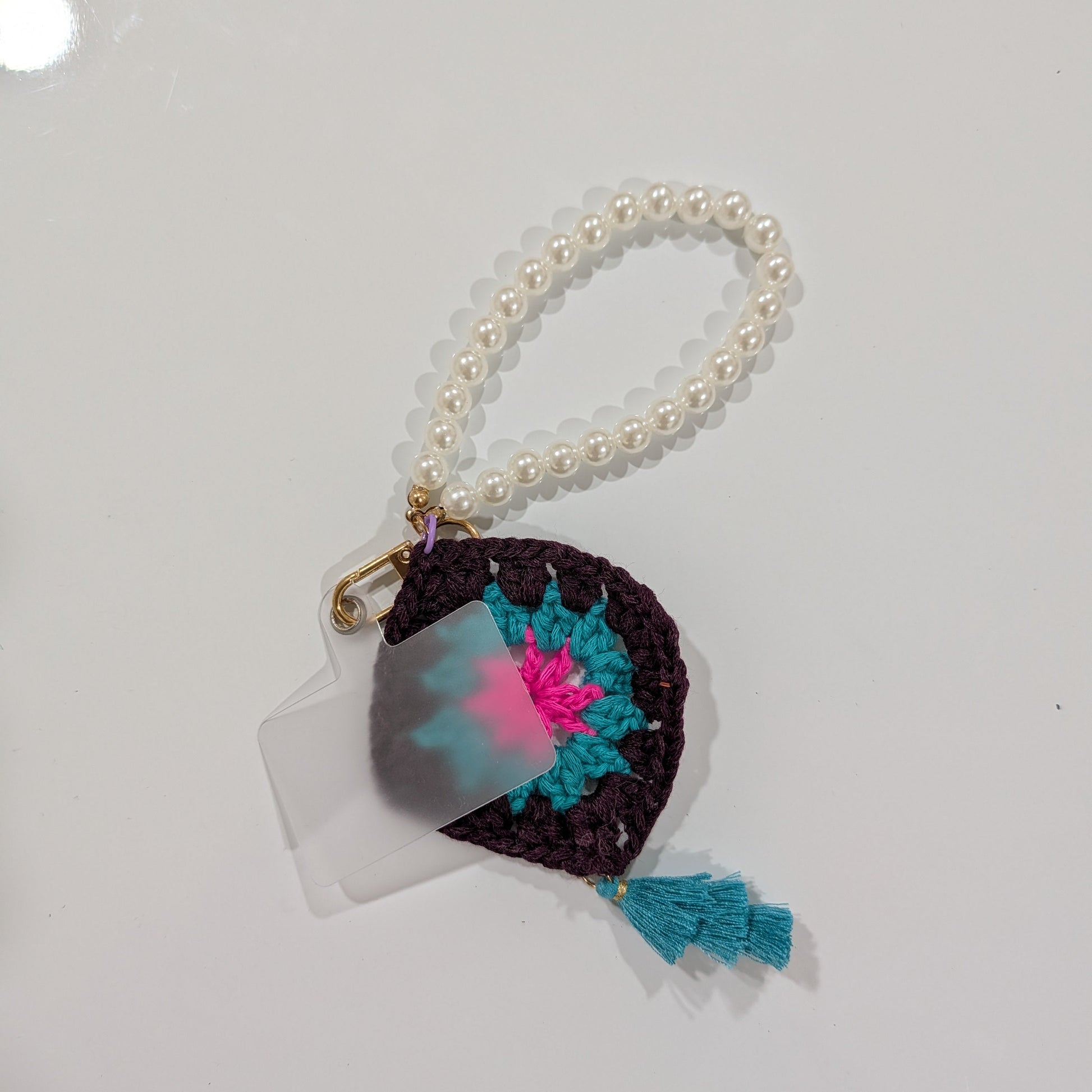 Small crocheted keychain and beads bracelet with colorful design on a white background