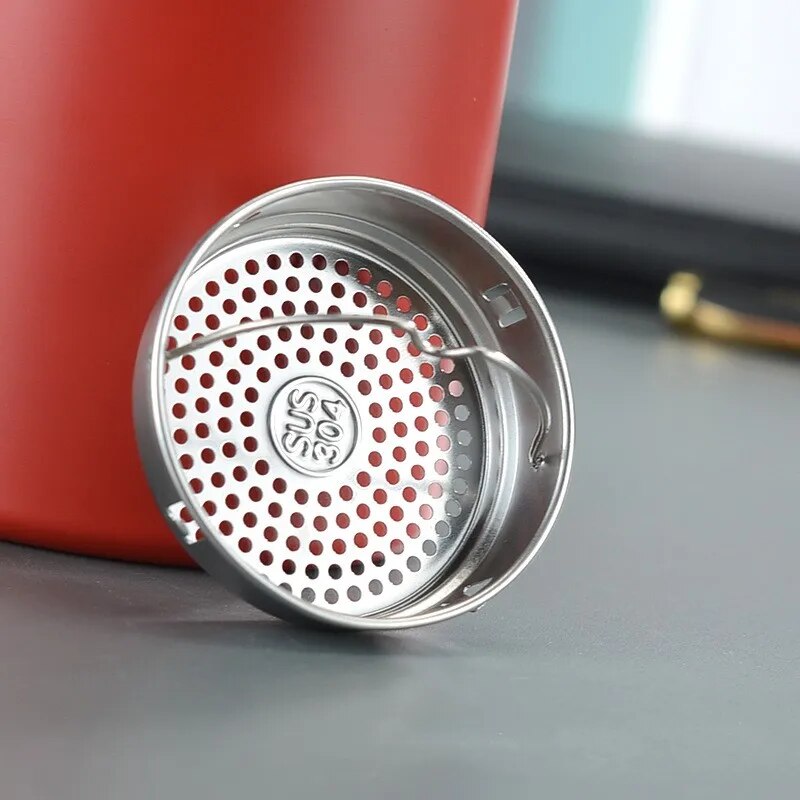 Image for red stainless steel double wall insulated water bottle with removable infusing filter placed next to it. The filter has a small ring wire attache to it for easy placement inside the bottle.