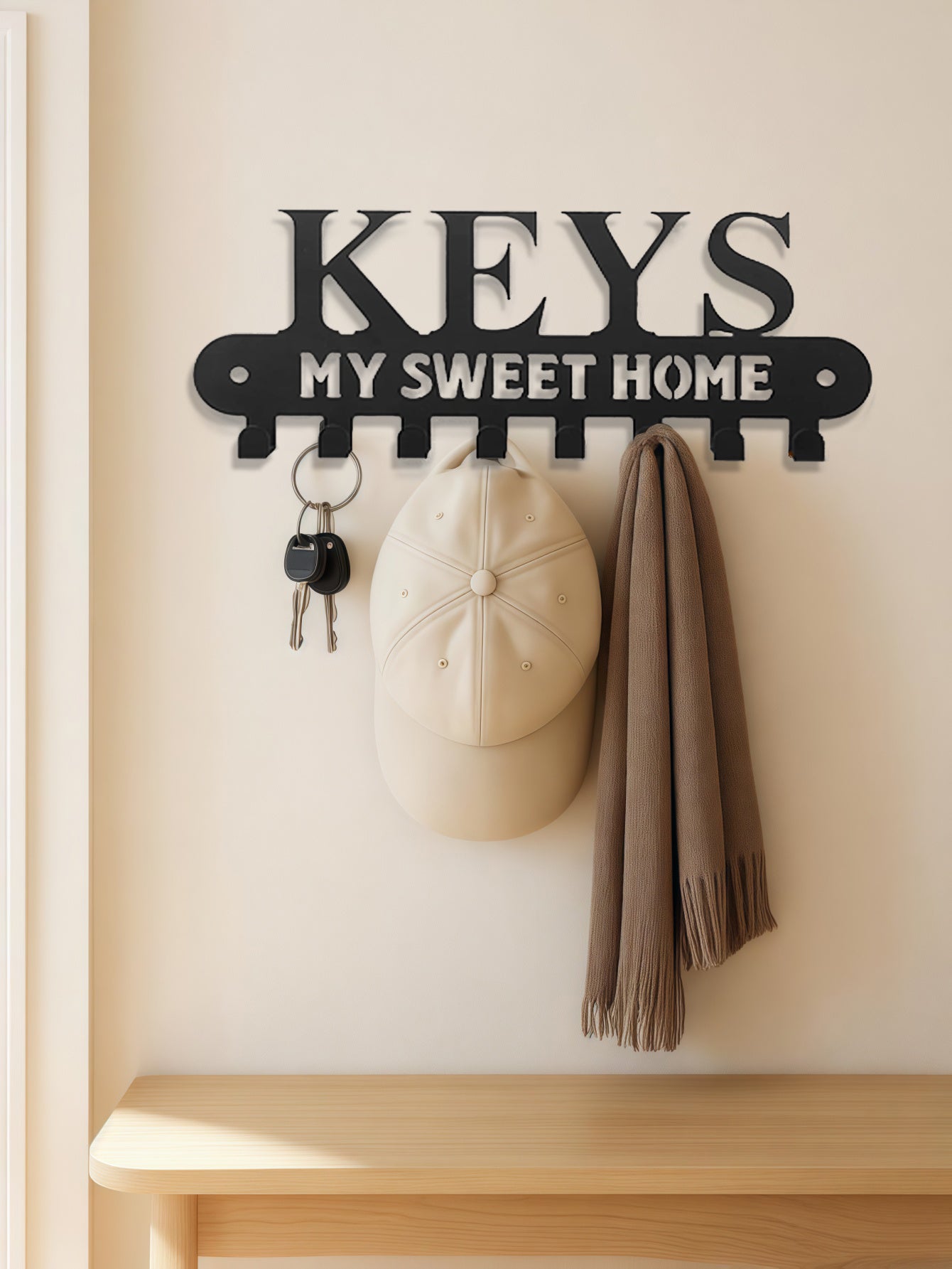 8-hook Key holder with 'KEYS MY SWEET HOME' text on a wall with a cap and coat hanging from it.