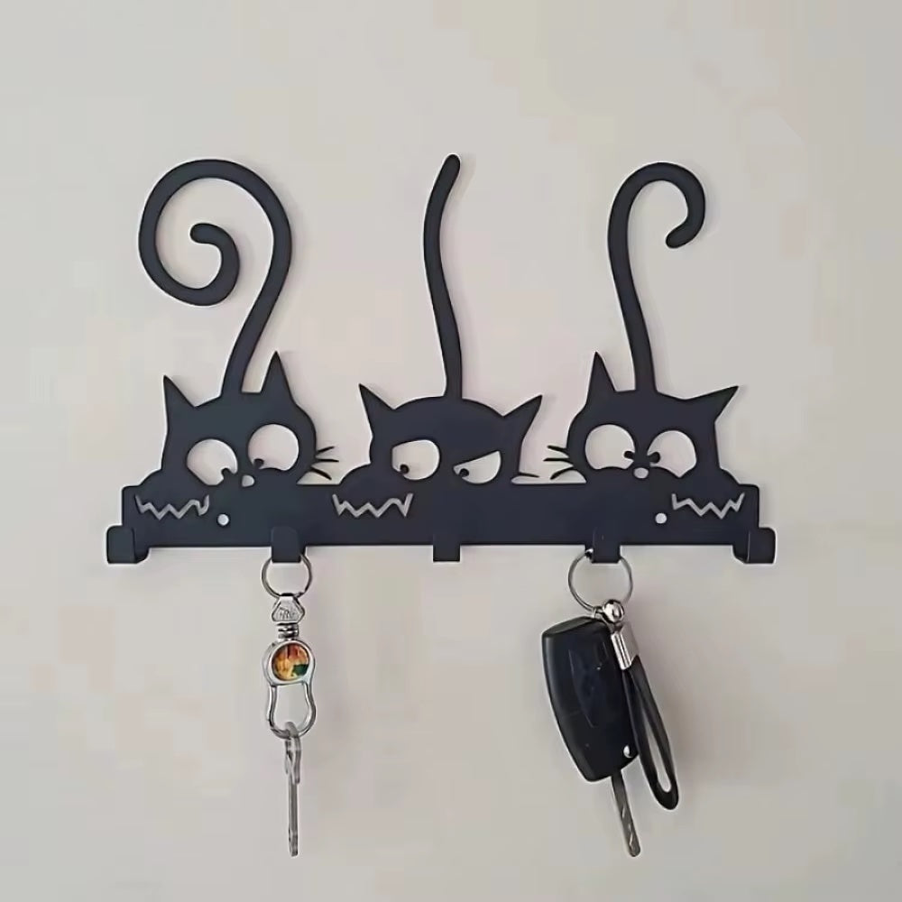 Black 5 hook cat-shaped wall mounted key holder with keys on a white background