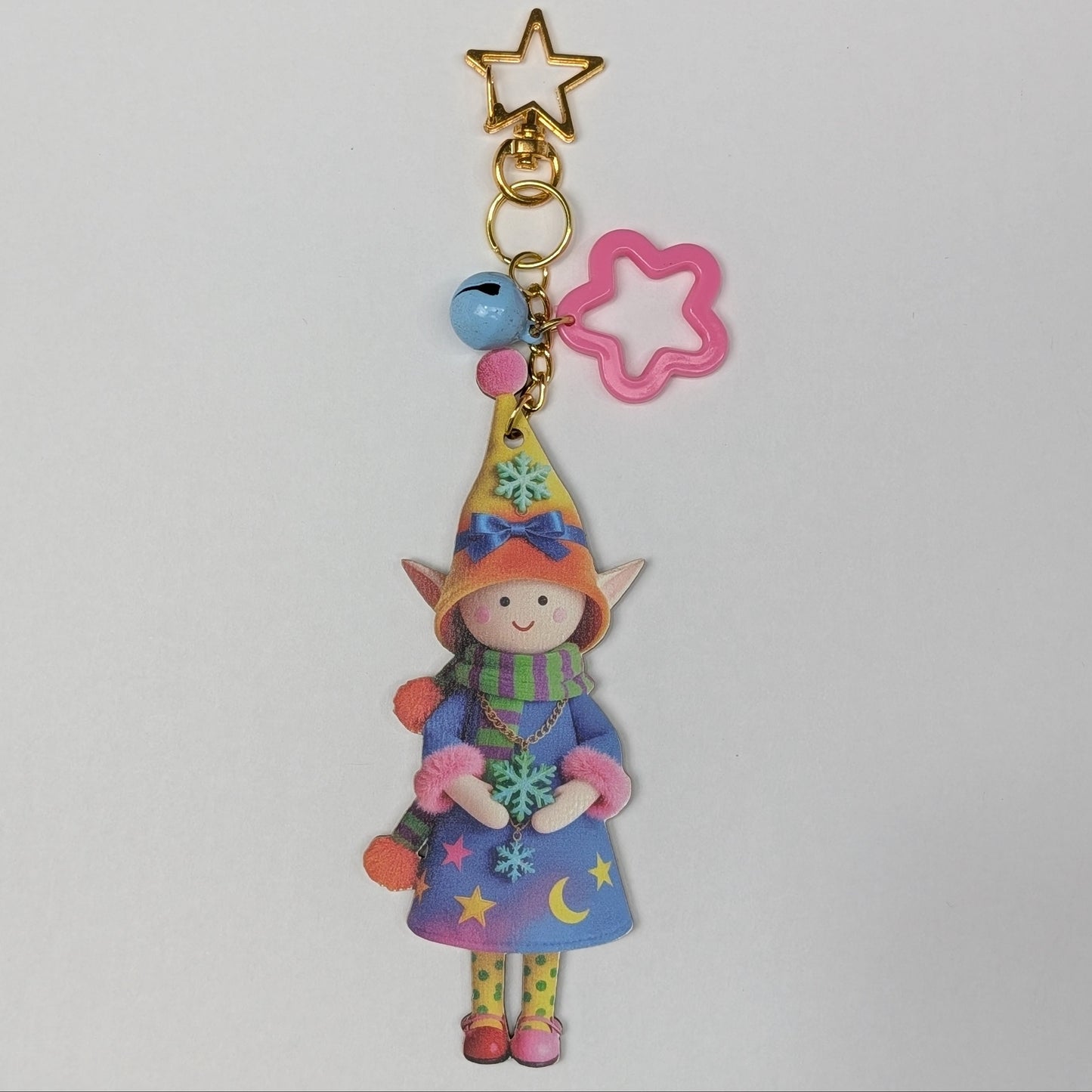 Colorful holiday character doll keychain with star, flower, and bell charms on a white background