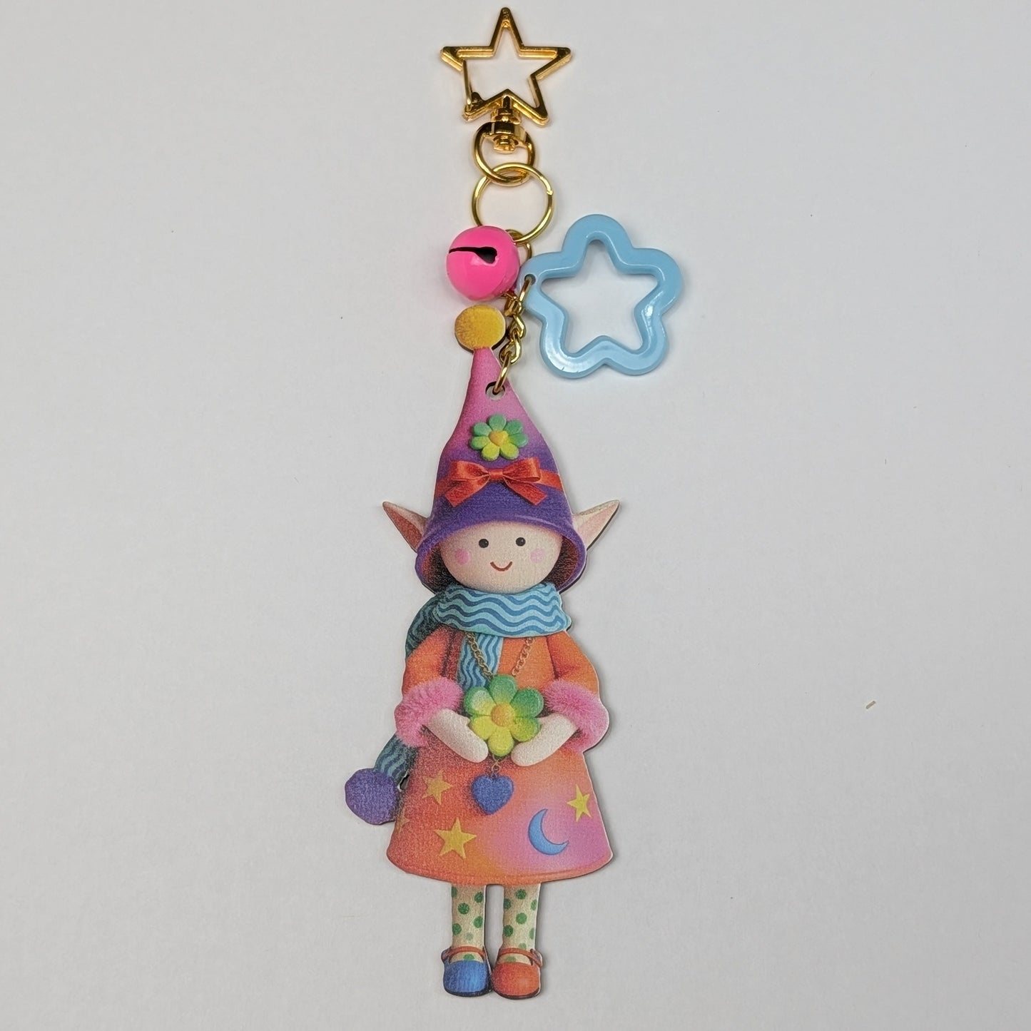Colorful holiday theme fairy charm keychain with star and rattle decorations on a white background