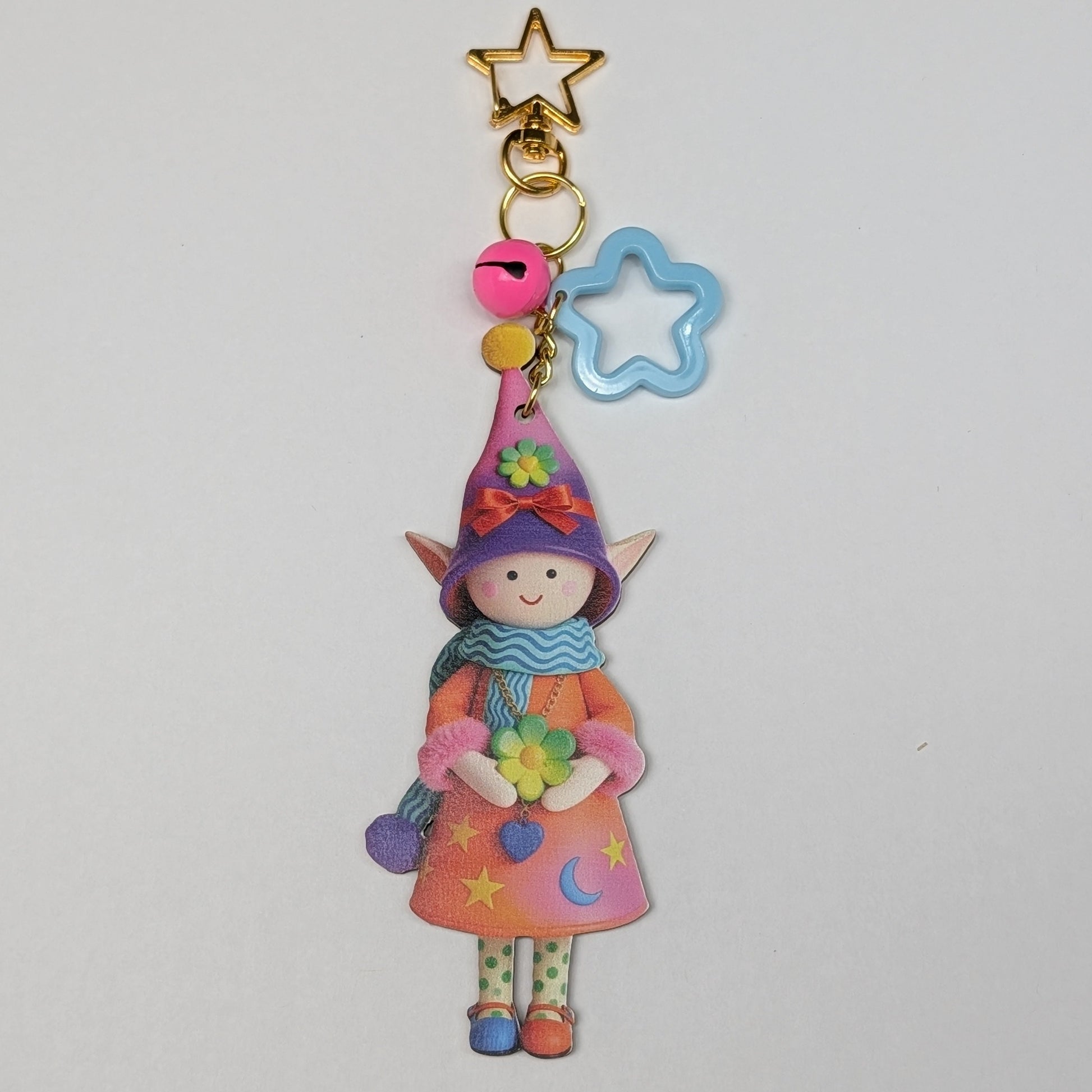 Colorful holiday theme fairy charm keychain with star and rattle decorations on a white background
