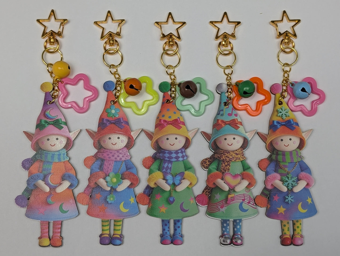 Colorful holiday theme fairy keychains with stars, rattles and flower charms on a white background