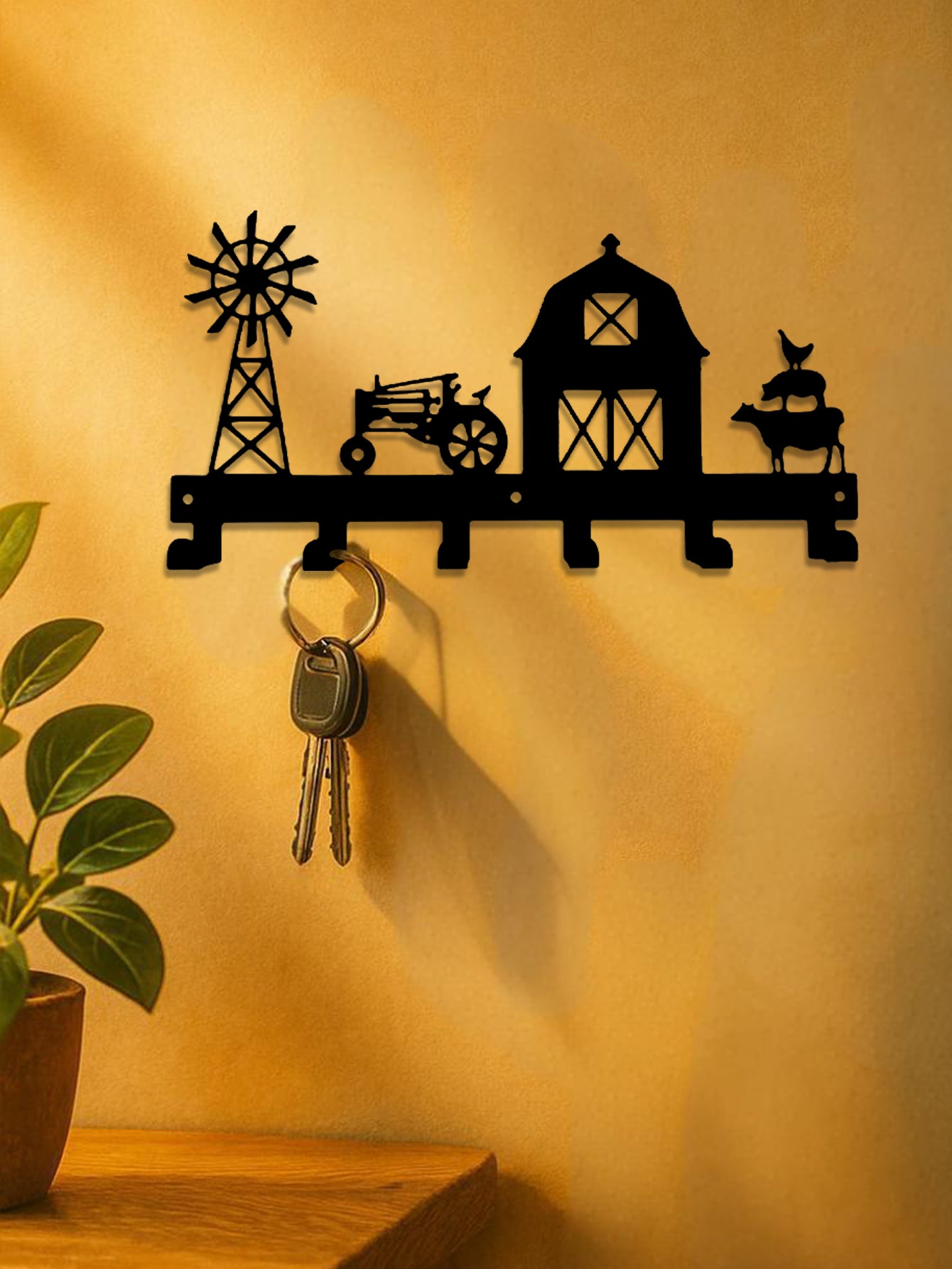 Decorative 6-hook wall mounted key holder with farm-themed design on a yellow wall.