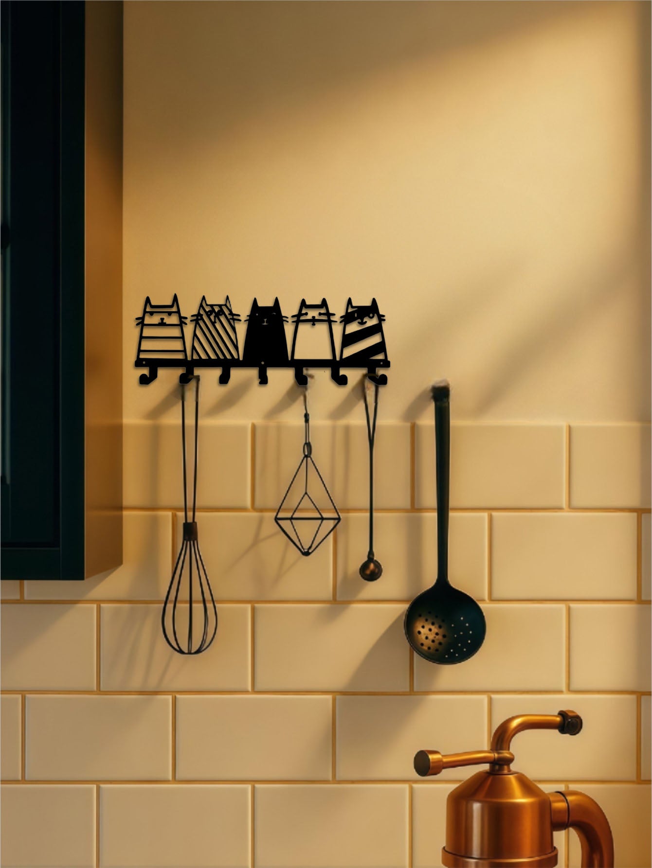 Decorative 7-hook wall mounted key rack with cat designs on a tiled kitchen wall.