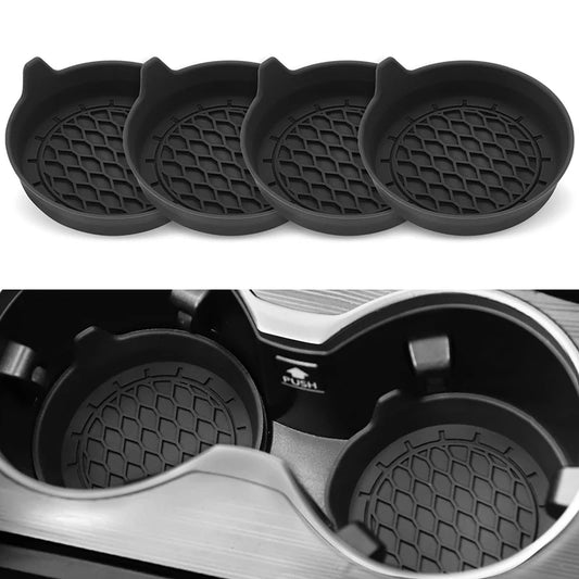 Four black silicone coasters with a textured surface on a white background, one coaster is shown inside an air fryer.