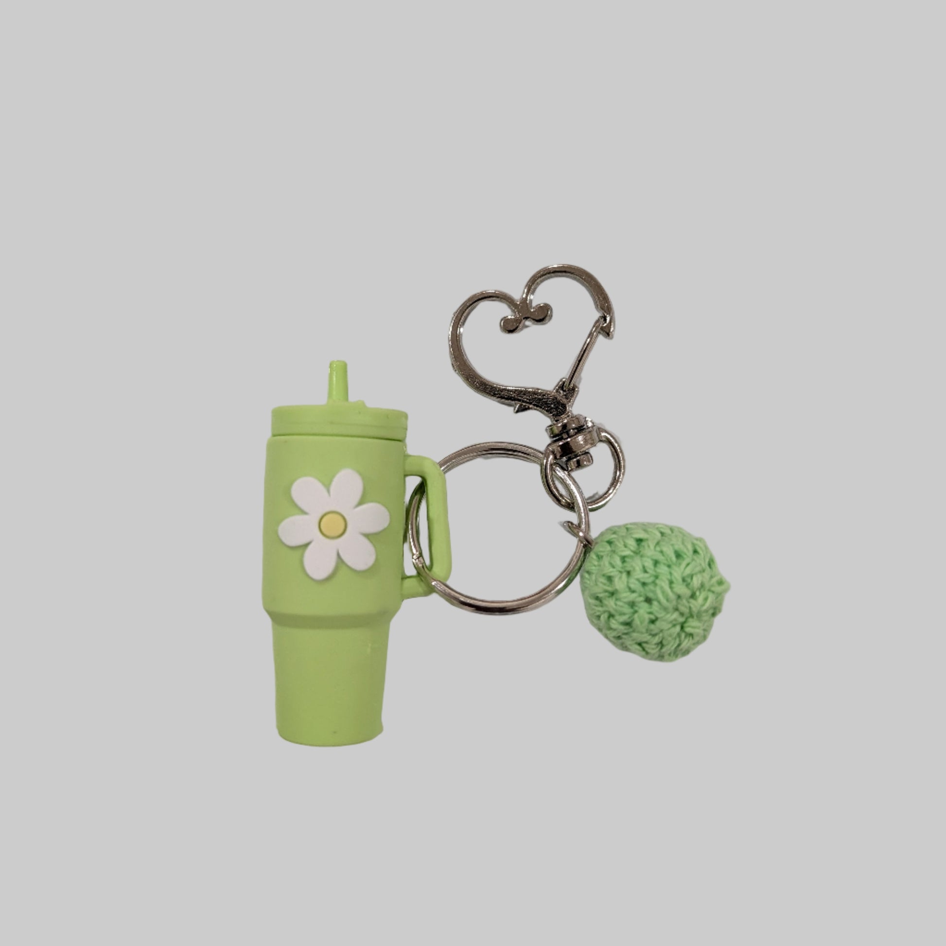 Green little silicone tumbler keychain with a flower design on a white background