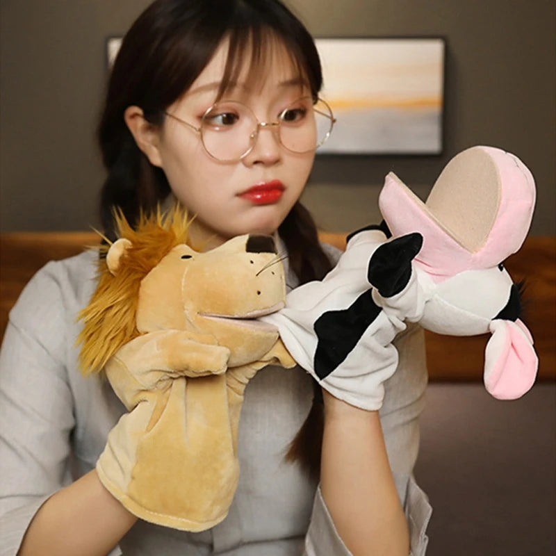 Person holding and playing with a lion and a cow plush hand puppet