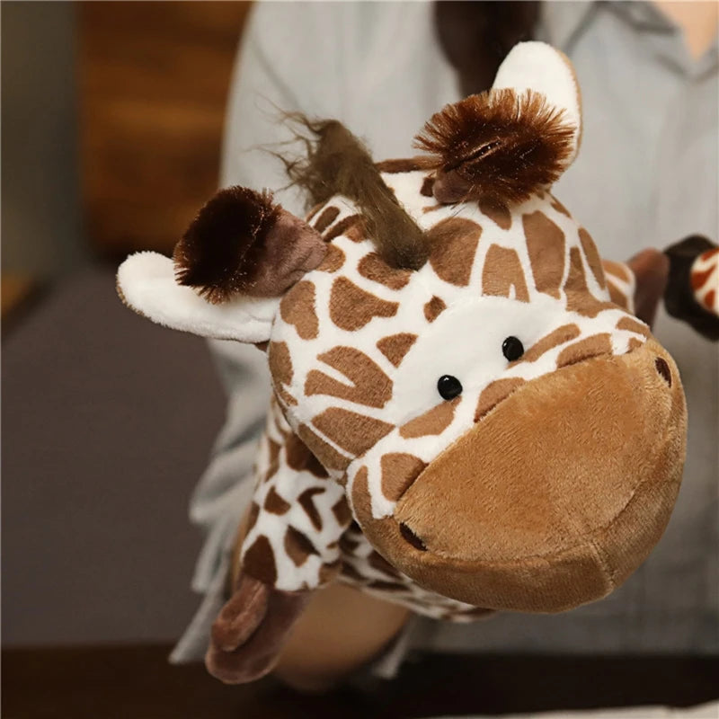 Plush giraffe hand puppet held by a person with a blurred background