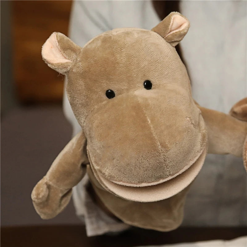 Plush hippo hand puppet held by a person with a blurred background