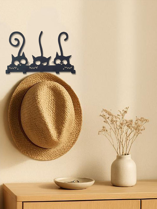 Wall-mounted 5-hook cute cats design key and hat rack with a straw hat on a beige wall above a wooden surface with a vase and bowl.