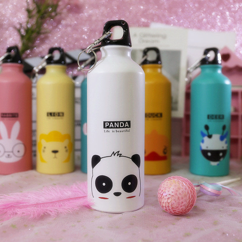 Image for stainless steel reusable water bottle for kids in white color with panda face print on it. It has Panda text and a "Life is beautiful" quote printed right above it. The bottle is shown standing straight with a small decoration ball lying next to it and few other similar bottles in the background.