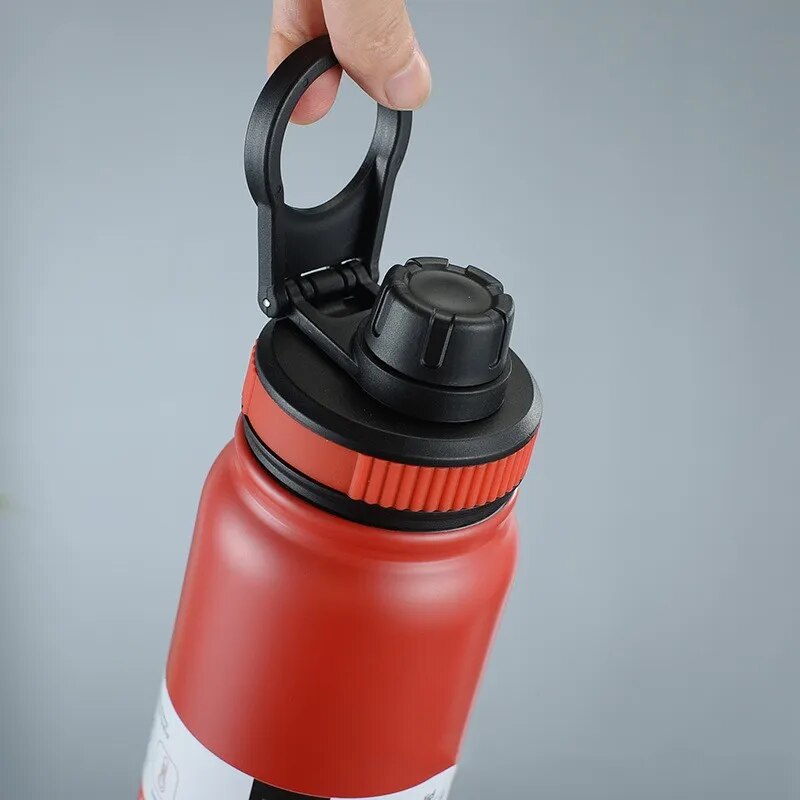 Image for the red stainless steel double wall insulated water bottle being held in the hand using the attached carry loop.