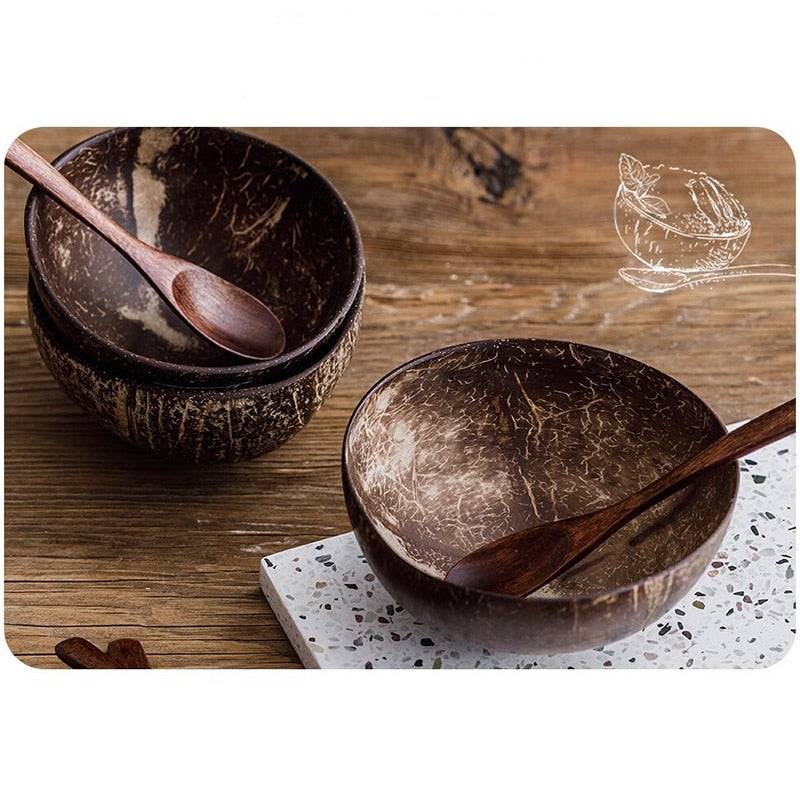 Image for coconut bowls place on wooden and stone boards. Two coconut bowls one on top of other with wooden spoon in it, and another bowl on stone board with spoon in it.