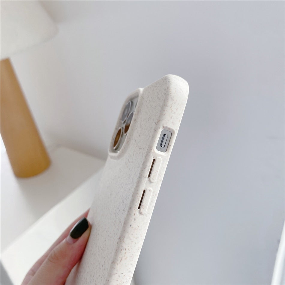 Image for iPhone inside a white textured phone case made of compostable wheat straw material. The image is showing side buttons view of the phone inside the case.
