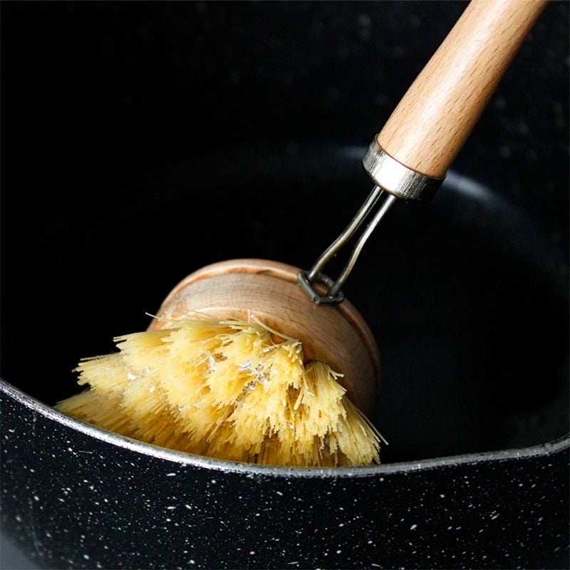 Image for long handle bamboo cleaning brush being used to scrub a frying pan.