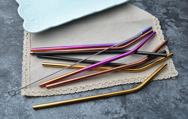 Image for reusable stainless steel drinking straws in mixed colors placed on a piece of cloth. A straw cleaning brush is also placed alongside.