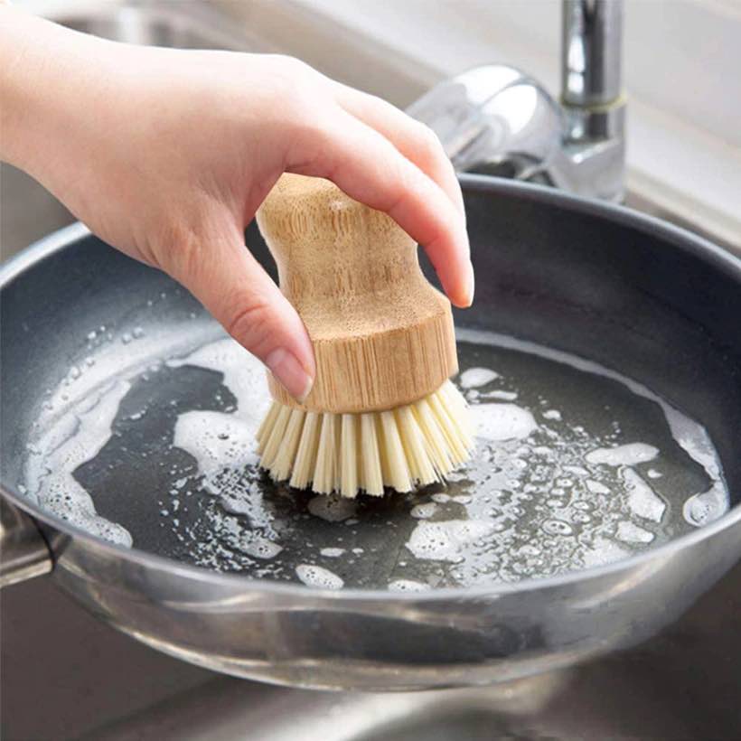 Image for small bamboo bowl brush being used to clean a frying pan.