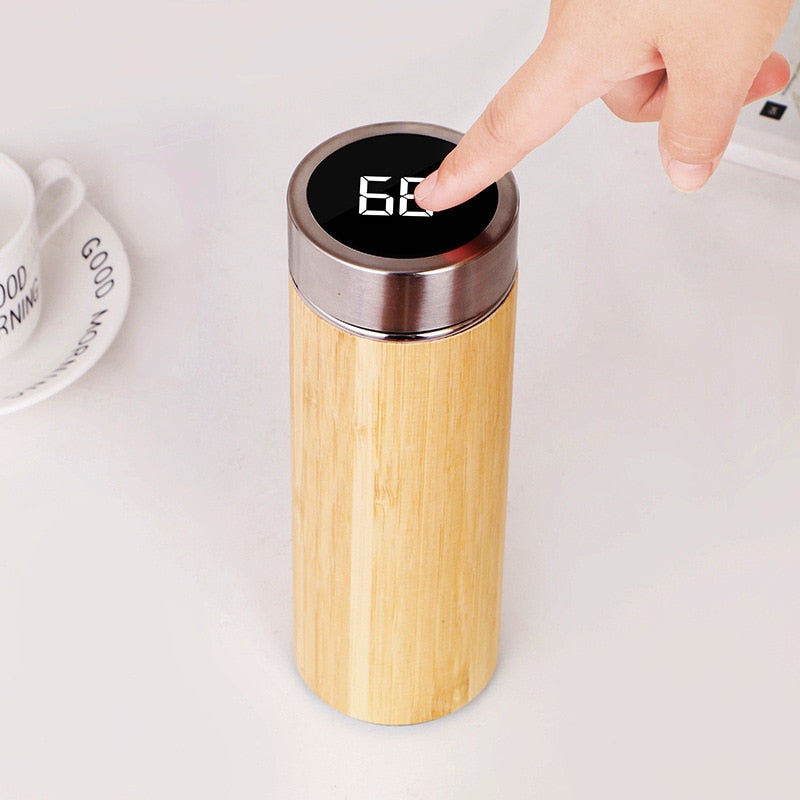 Image for stainless steel thermos flask with lid placed upright. A person has placed their finger on the lid to check temperature.