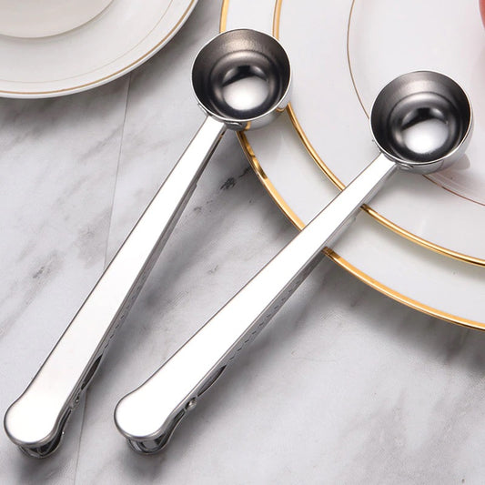 Image for two stainless steel two-in-one spoon and sealers placed on a plate. Color of spoons is silver.